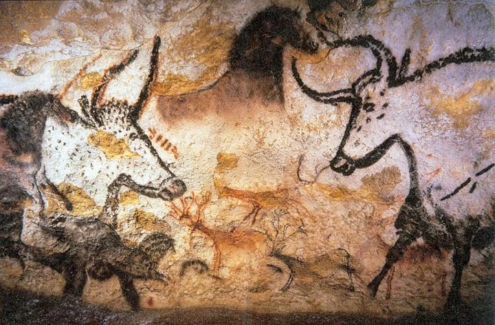 Cave painting of two large aurochs with horses and deer, in black and red ochre